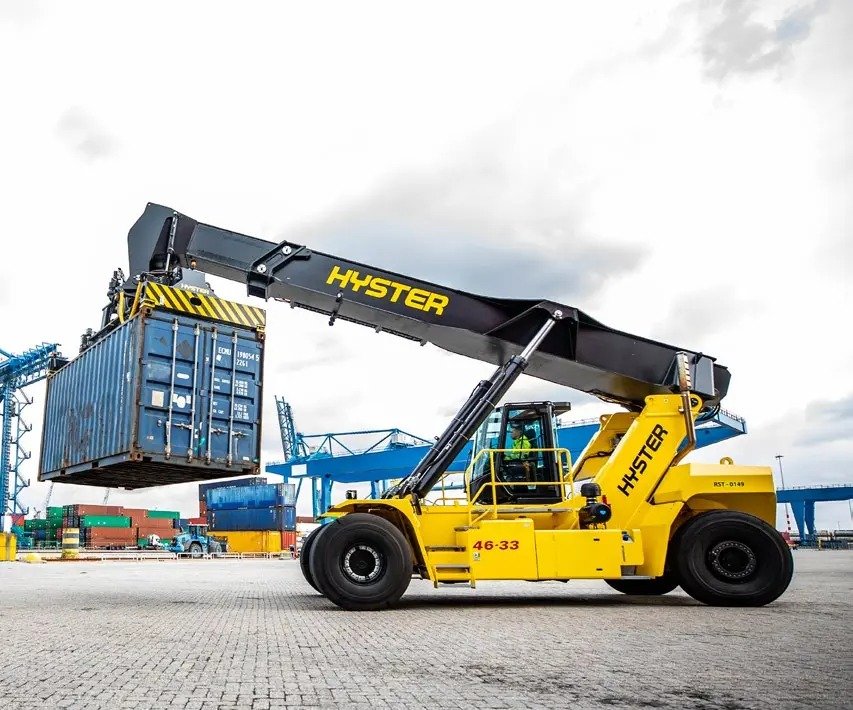 Reach stacker lifting a shipping container at a port terminal